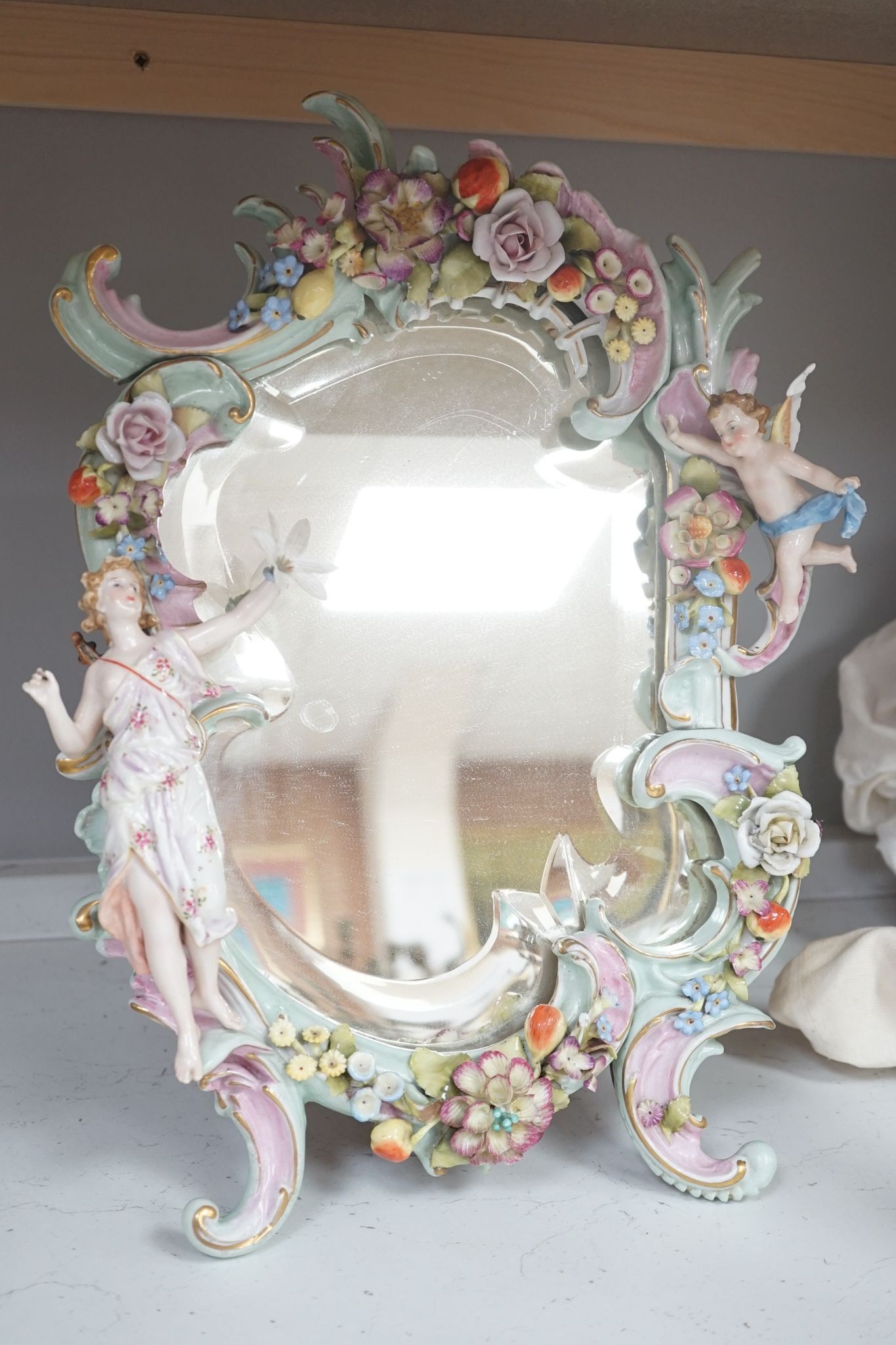 Two German porcelain easel mirrors and a Belleek easel mirror, tallest 43cm